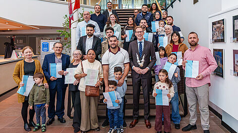 Groepsfoto van de nieuwe Nederlanders en wethouder Jeroen Postma