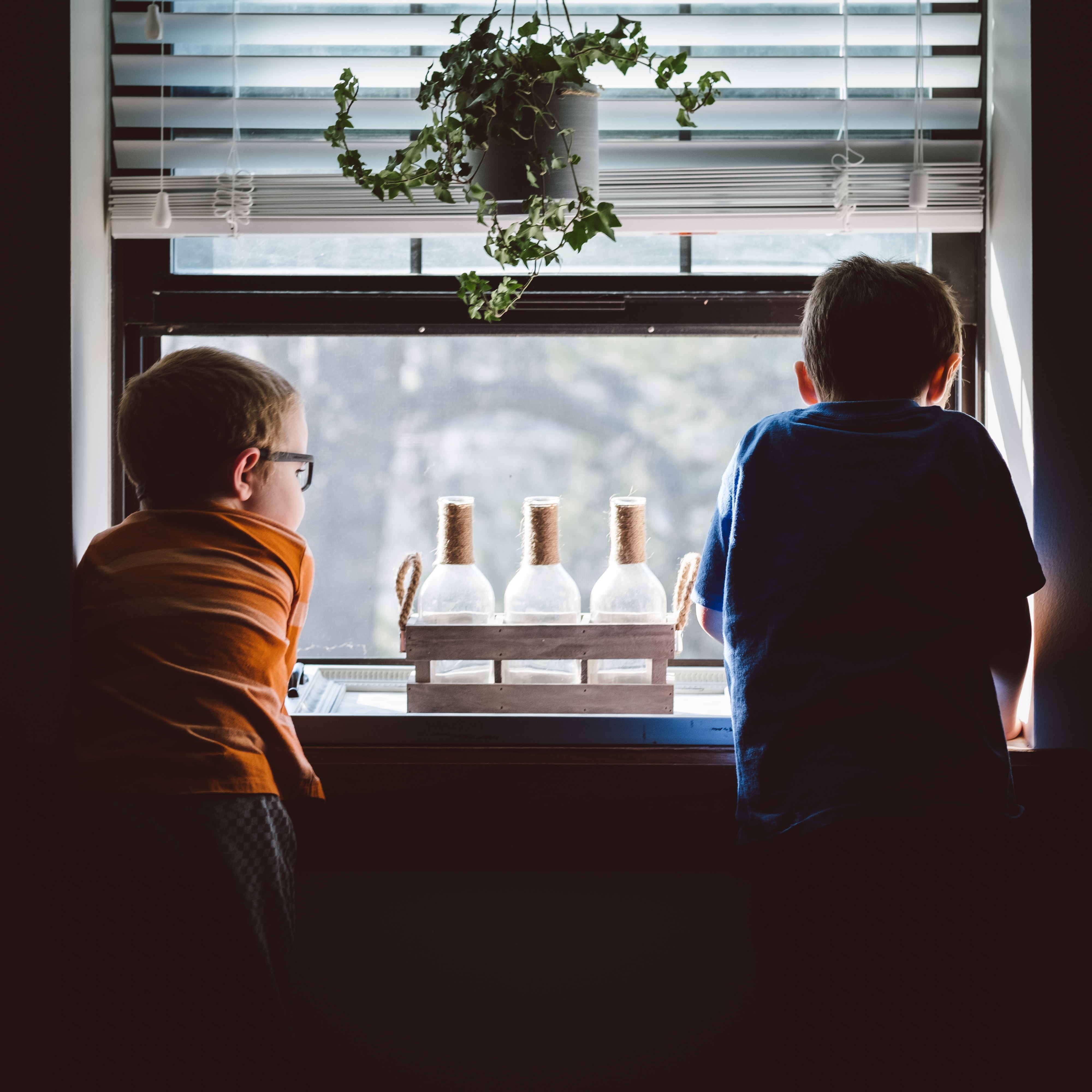 Foto van twee jongens die uit het raam kijken